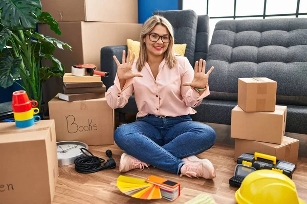 Young Hispanic Woman Moving New Home Sitting Floor Showing Pointing — Stock Photo, Image