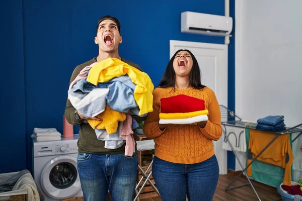 Young Couple Holding Laundry Dirty Clean Laundry Angry Mad Screaming — 图库照片