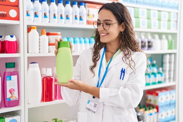 Young Beautiful Hispanic Woman Pharmacist Holding Shampoo Bottle Pharmacy — Stock Photo, Image