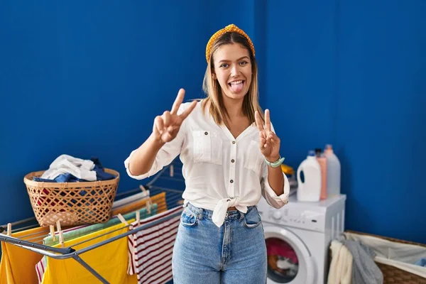 Çamaşır Odasındaki Genç Sarışın Kadın Iki Elini Göstererek Gülümseyerek Zafer — Stok fotoğraf