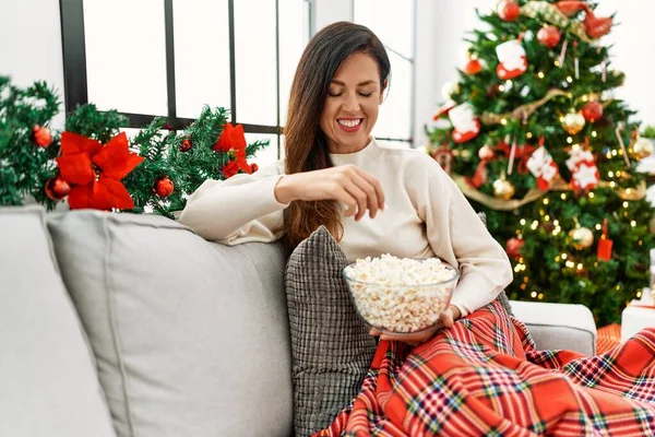 Middelbare Leeftijd Spaanse Vrouw Eten Popcorn Kijken Zitten Door Kerstboom — Stockfoto
