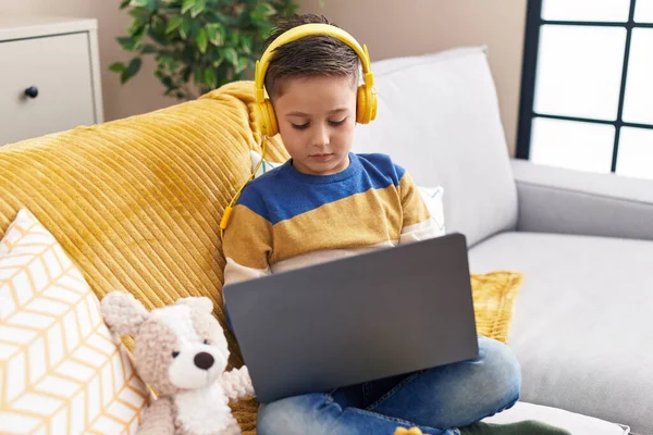 Adorable Hispanic Boy Using Laptop Headphones Sitting Sofa Home — Stock Photo, Image