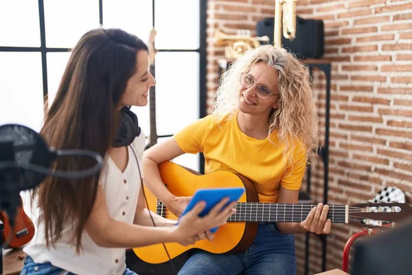 Duas Mulheres Músicos Tocando Guitarra Clássica Procurando Touchpad Estúdio Música — Fotografia de Stock