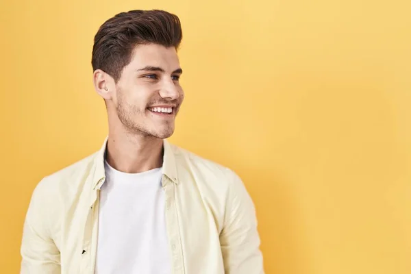 Young Hispanic Man Standing Yellow Background Looking Away Side Smile — Stockfoto
