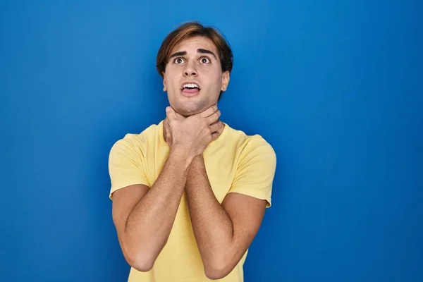 Young Man Standing Blue Background Shouting Suffocate Because Painful Strangle — Foto de Stock