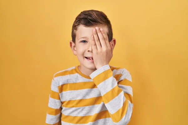 Mladé Bělošské Dítě Stojící Nad Žlutým Pozadím Zakrývající Jedno Oko — Stock fotografie