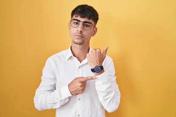 Junger Hispanischer Mann Steht Vor Gelbem Hintergrund Eile Und Zeigt — Stockfoto