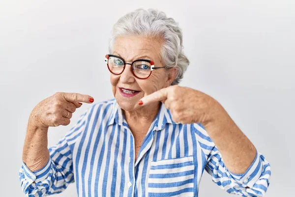 白髪のシニア女性が白い背景の上に立って 陽気で 指の歯と口を指差して笑っています 歯の健康の概念 — ストック写真