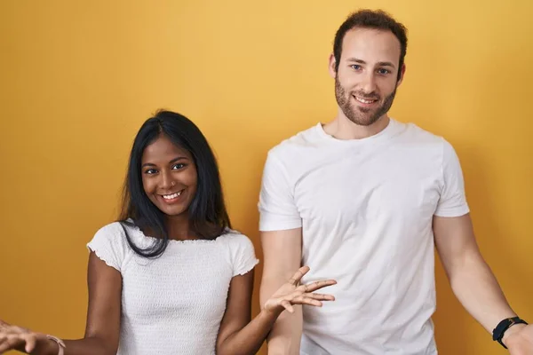 Interracial Couple Standing Yellow Background Smiling Cheerful Open Arms Friendly — 图库照片