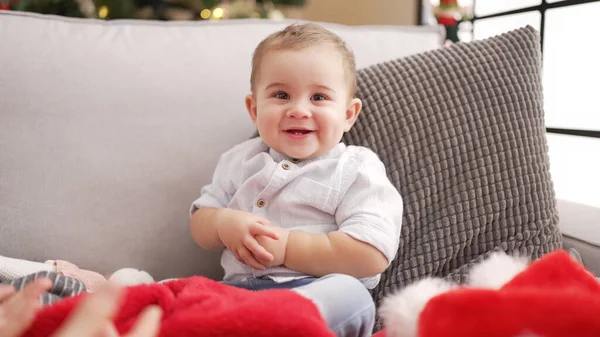可爱的幼儿在家里坐在圣诞树旁的沙发上 自信地微笑着 — 图库照片