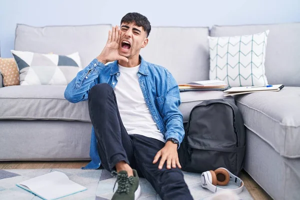 Young Hispanic Man Sitting Floor Studying University Shouting Screaming Loud — Foto de Stock