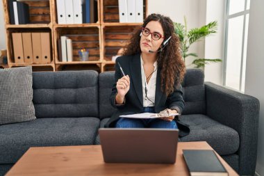 Genç ve güzel İspanyol iş kadını ofiste video görüşmesi yapıyor.