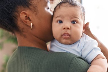 Anne ve oğul evde birbirlerine sarılıyorlar.