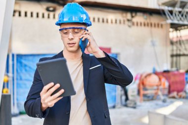 Genç İspanyol mimar, dokunmatik ped kullanıyor ve caddede akıllı telefondan konuşuyor.