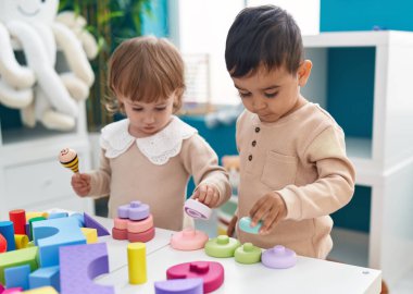 Anaokulunda inşaat bloklarıyla oynayan iki çocuk.