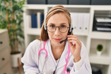 Young blonde woman doctor having telemedicine at clinic