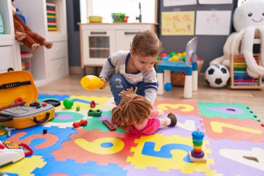 Anaokulunda pin bowlingi oynayan sevimli beyaz çocuk.
