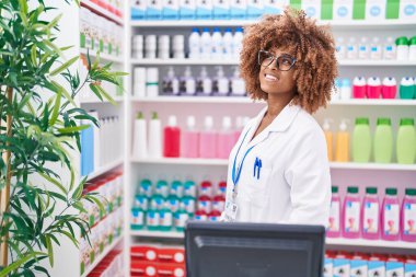 Eczanede kendine gülen Afrikalı Amerikalı kadın eczacı.