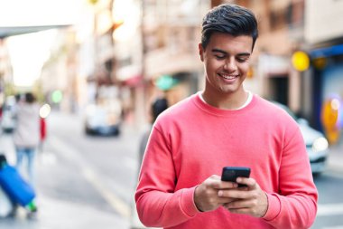 Sokakta akıllı telefon kullanan, kendine güvenen genç bir İspanyol.