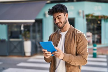 Sokakta dokunmatik ped kullanan, kendine güvenen İspanyol genç adam.