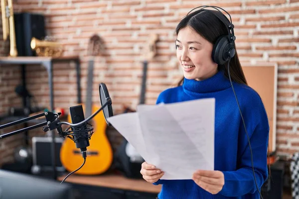 Chinese woman artist singing song at music studio