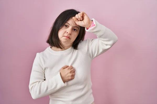 病気や熱のための額に触れるピンクの背景に立っているダウン症候群の女性 インフルエンザや風邪 ウイルス病 — ストック写真