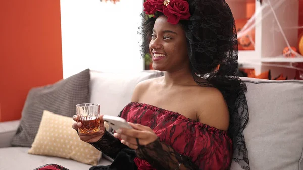 African American Woman Wearing Katrina Costume Using Smartphone Drinking Whisky — Stock Photo, Image