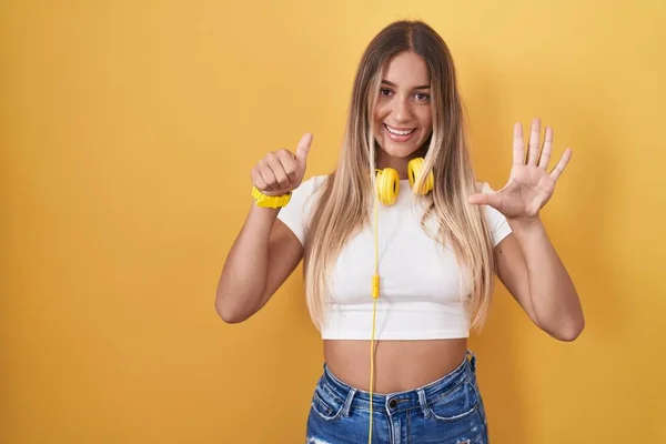 Young Blonde Woman Standing Yellow Background Wearing Headphones Showing Pointing —  Fotos de Stock