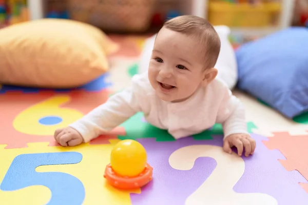 Liebenswertes Kleinkind Lächelt Kindergarten Selbstbewusst Auf Dem Boden Liegend — Stockfoto