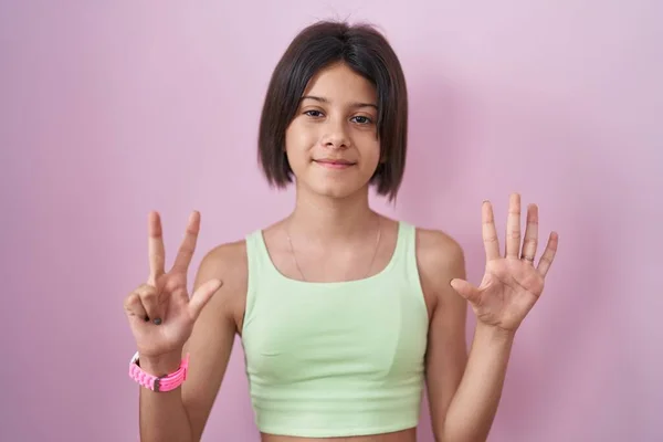 Молодая Девушка Стоит Розовом Фоне Показывая Показывая Пальцами Номер Восемь — стоковое фото