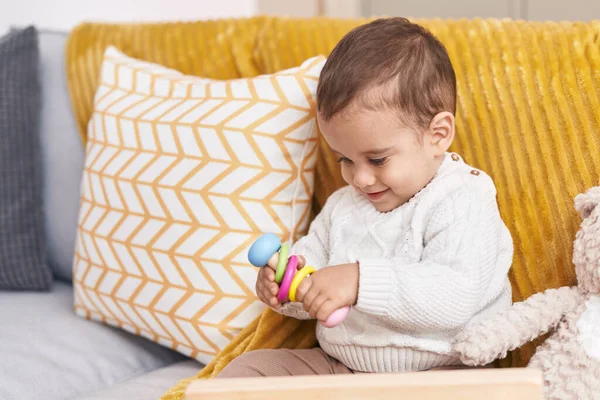 Sevimli Spanyol Bebek Evdeki Kanepede Oturmuş Oyuncakla Oynuyor — Stok fotoğraf