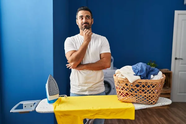 Young Hispanic Man Beard Ironing Clothes Home Thinking Concentrated Doubt — Photo