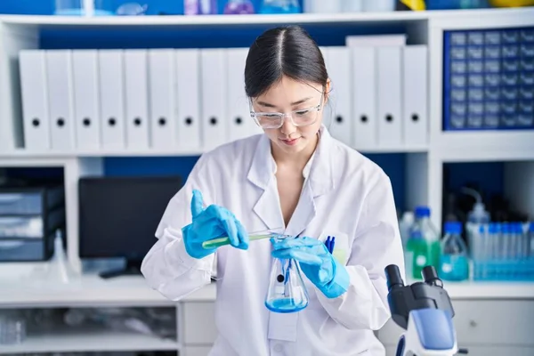 実験室で試験管に液体を注ぐ中国の女性科学者 — ストック写真