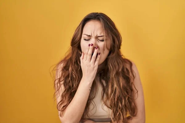 Sarı Arka Planda Dikilen Genç Spanyol Kadın Ağzıyla Ağzını Kapatmaktan — Stok fotoğraf