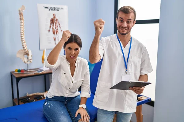 Young Hispanic Woman Physiotherapist Appointment Angry Mad Raising Fist Frustrated — Stockfoto