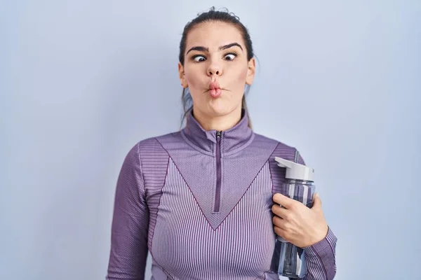 Beautiful Woman Wearing Sportswear Holding Water Bottle Making Fish Face — Zdjęcie stockowe