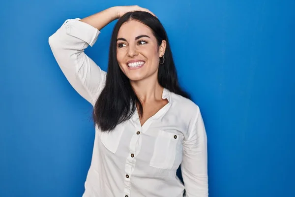 Young Hispanic Woman Standing Blue Background Smiling Confident Touching Hair — 图库照片