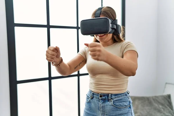 若いですヒスパニック女性遊びビデオゲームを使用して仮想現実の眼鏡で自宅 — ストック写真