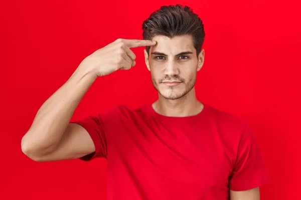 Young Hispanic Man Standing Red Background Pointing Unhappy Pimple Forehead — Stockfoto