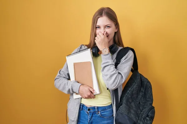 Young Caucasian Woman Wearing Student Backpack Holding Books Smelling Something — Stockfoto