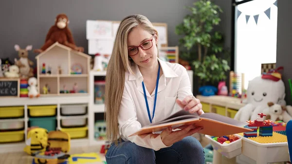Young Blonde Woman Preschool Teacher Reading Book Sitting Kindergarten — Foto Stock
