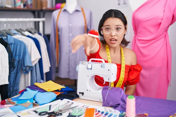 Hispanic Young Woman Dressmaker Designer Using Sewing Machine Pointing Finger — Stockfoto