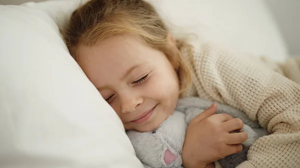 Adorable Blonde Girl Hugging Rabbit Doll Lying Bed Bedroom — Stock fotografie