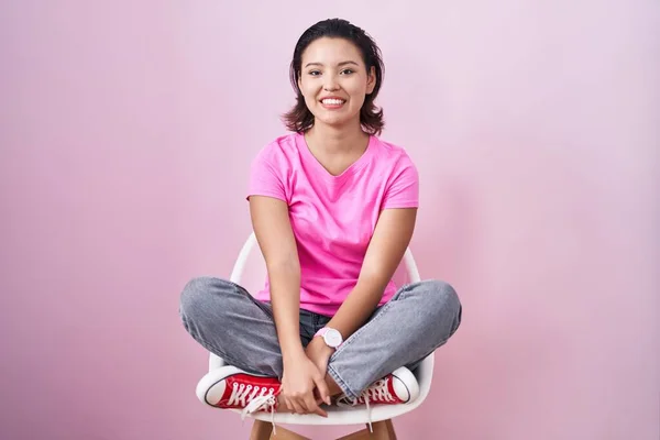 Hispanic Young Woman Sitting Chair Pink Background Happy Cool Smile — 图库照片