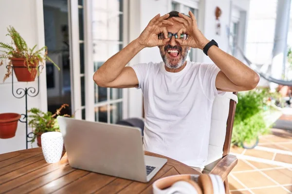Middle Age Man Using Computer Laptop Home Doing Gesture Binoculars — Φωτογραφία Αρχείου