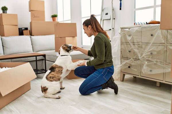 Молодая женщина обучает собаку дома