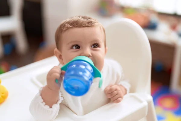 유치원에서 의자에 식수를 마시고 스러운 갓난아기 — 스톡 사진