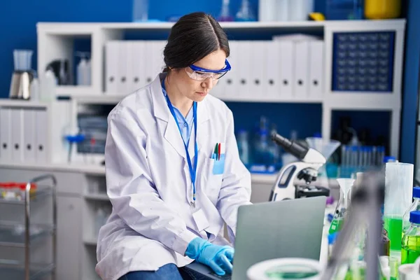 Young woman scientist using laptop at laboratory