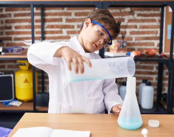 Sevimli İspanyol öğrenci laboratuvar sınıfında test tüpüne sıvı döküyor.