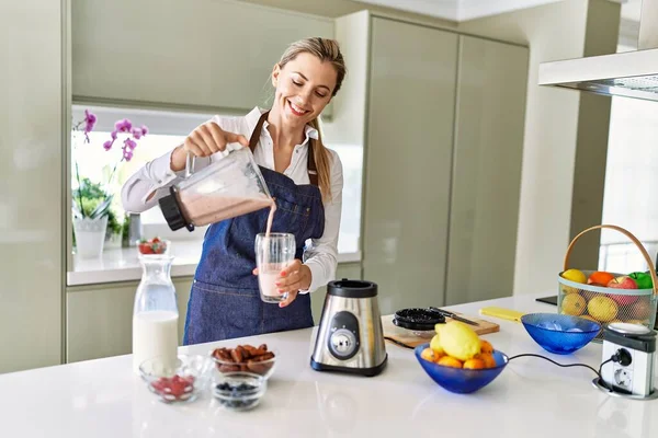 Young Blonde Woman Smiling Confident Pouring Smoothie Glass Kitchen — Stock Photo, Image